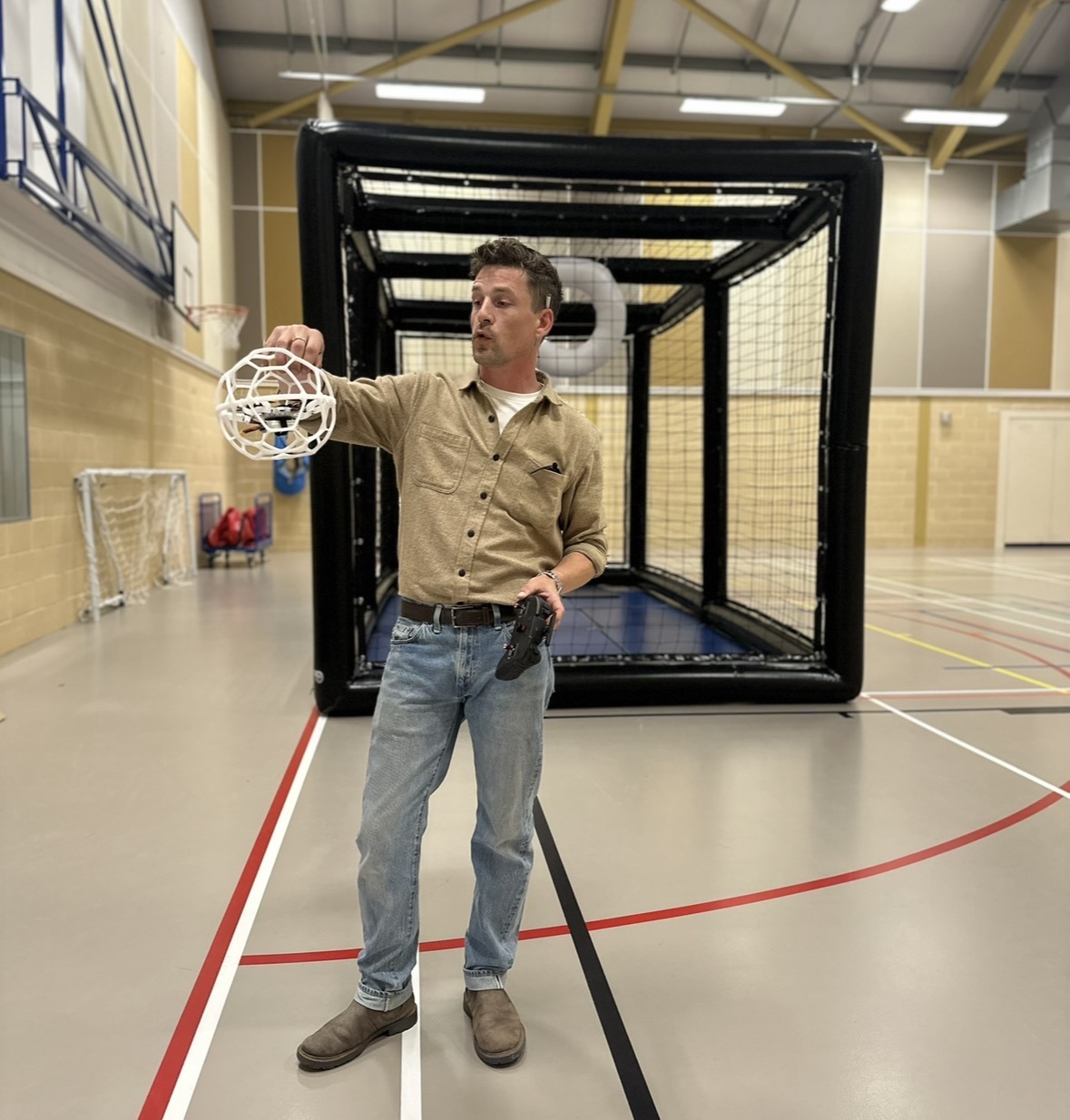 A facilitator demonstrating a caged drone in front of the arena