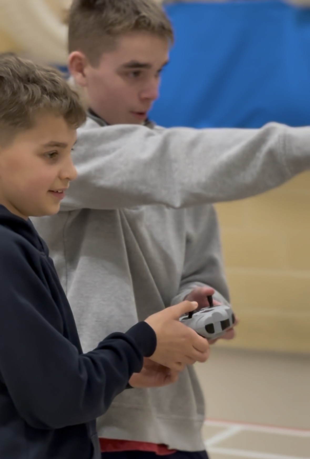 An older participant coaching a younger pilot mid-flight
