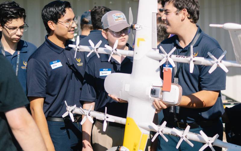 Young people examining an industrial delivery drone